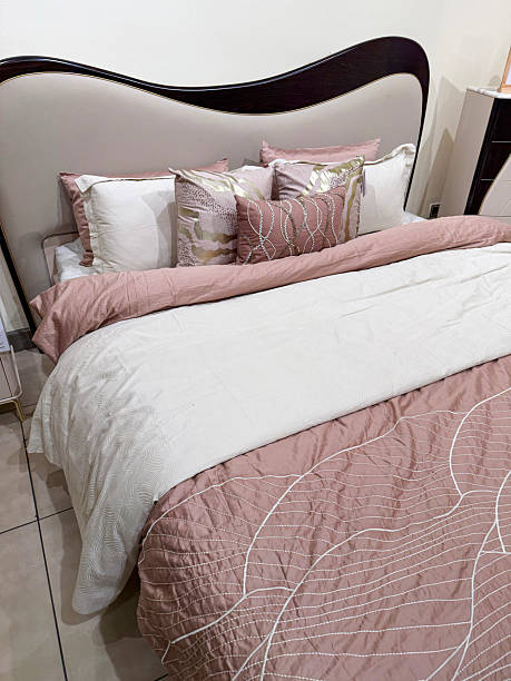 istock Image of double bed with pink and grey duvet set, lined sheets, scatter cushions, patterned quilt, coordinated pillows, soft throw 2243490938