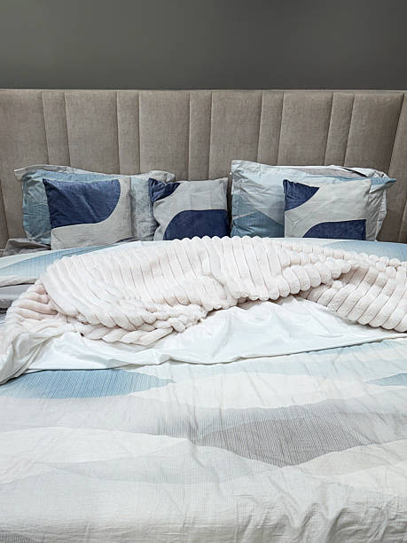 istock Image of modern bedroom, double bed, pale blue duvet set, lined sheets, patterned quilt, matching pillows, elegant headboard 2243491378