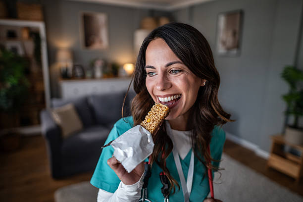 istock Nurse enjoying healthy granola bar snack during home visit break 2243492297