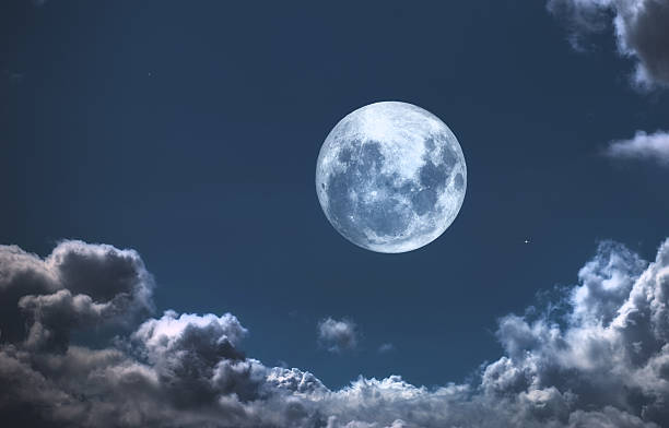 istock Bright full moon illuminating the night sky amidst scattered clouds 2243493429
