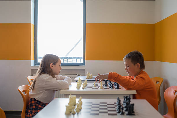 Young children school student playing chess in classroom at school