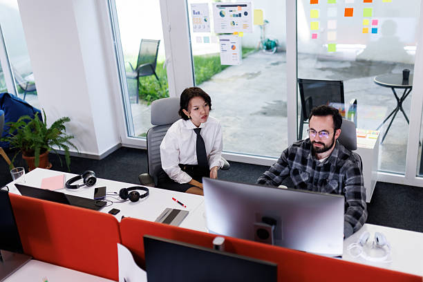 istock Business meeting between colleagues in a modern office space while discussing project details in the afternoon light 2243493913