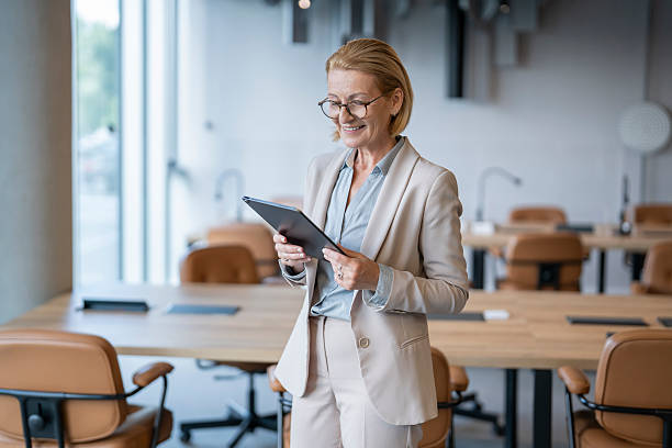 istock Smiling senior businesswoman using digital tablet in modern office 2243495395
