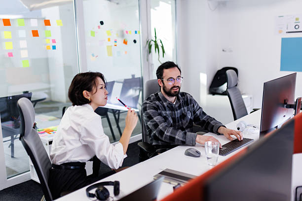 istock Business professionals collaborate in a modern office space, focusing on tasks while utilizing technology during a productive work session 2243499588