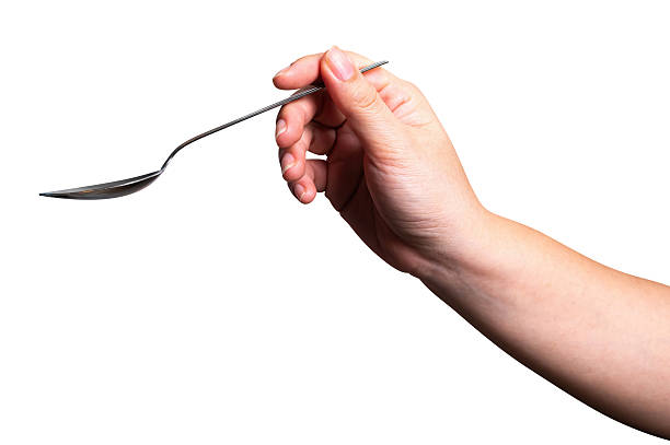 istock Female hand holding a black plastic spoon isolated on white background. 2243500863