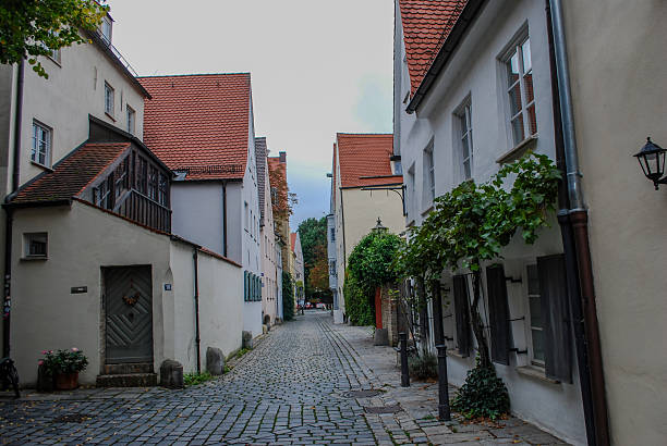 A narrow cobblestone street winds through Augsburg’s old town, framed by pastel buildings and flowered window boxes. The early evening light and tranquil atmosphere evoke the beauty of European village life and timeless Bavarian architecture.Keywords: Augsburg Germany, cobblestone street, Bavaria, old town, architecture, travel, European village, tourism, historic homes, charming street.