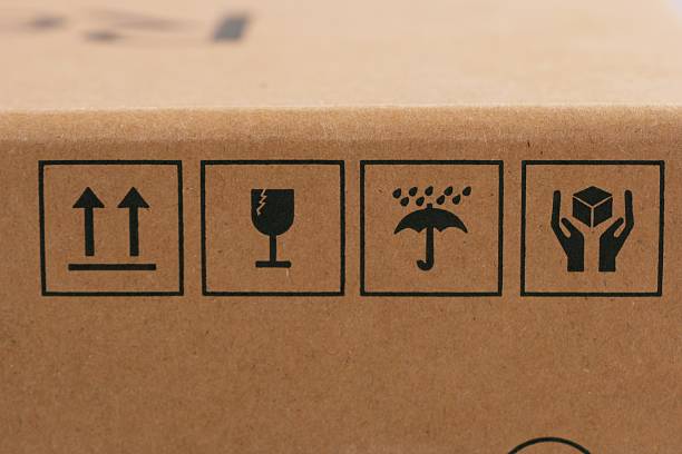 Close up of handling and fragile symbols printed on brown cardboard packaging box, concept of logistics, shipping and delivery.