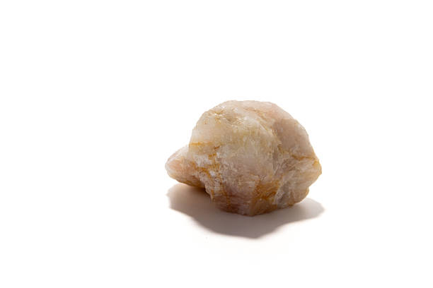 A rough rose quartz stone rests on a clean white backdrop, revealing soft pink tones and natural texture. Ideal for geology, jewelry, wellness, and decor imagery conveying calm and beauty.