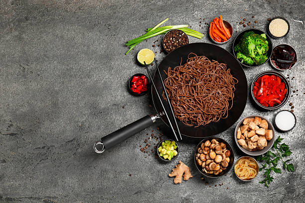 istock Wok with noodles, chicken and other products on grey table, flat lay. Space for text 2243506840