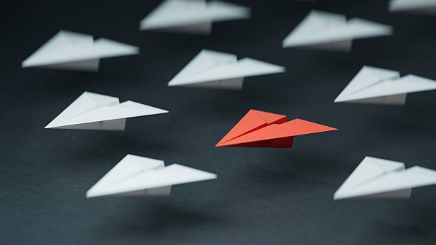 istock Different business concept.new ideas. paper art style. creative idea. red leader plane, standing out from the crowd of white planes.3D rendering on black background. 2243510211