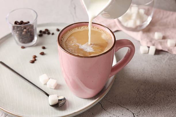 istock Pouring milk into cup with coffee on light grey textured table, closeup 2243510299