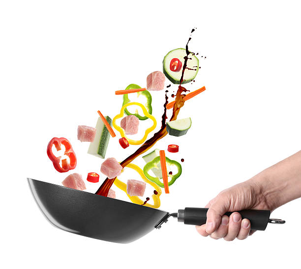 istock Man tossing ingredients in wok on white background, closeup 2243512143