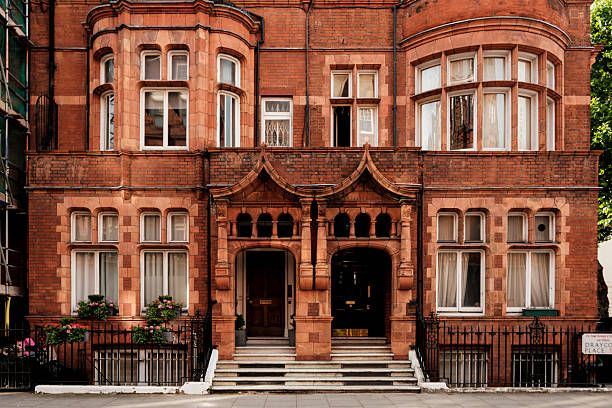 Red brick building showcasing historical victorian architecture with decorative entrances and bay windows, reflecting classic london urban residential design and british heritage