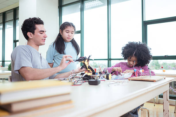 istock A teacher guiding students in a robotics project during a STEM class in the library 2243516305