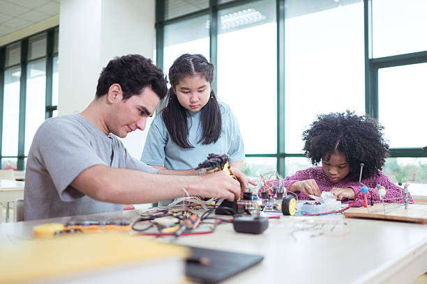 istock A teacher guiding students in a robotics project during a STEM class in the library 2243516306