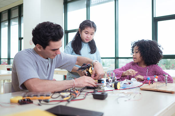 istock A teacher guiding students in a robotics project during a STEM class in the library 2243516308