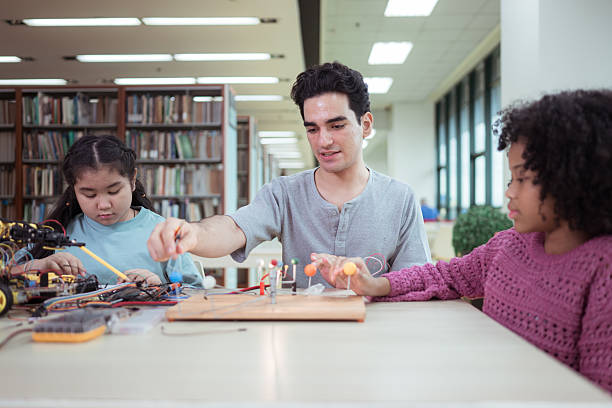 istock A teacher guiding students in a robotics project during a STEM class in the library 2243516320