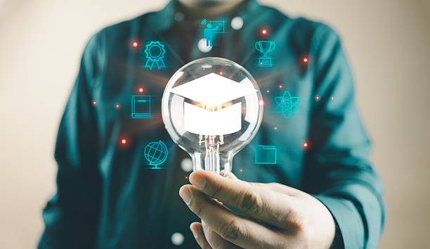 istock Man holding a lightbulb showing a graduation hat, an Internet education course degree 2243520464