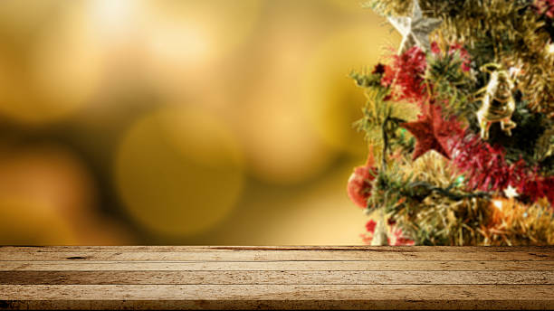 istock Wooden table and colorful Christmas tree decorations ornamented with blurred bokeh lights. Mockup or Copy space. Holiday greetings or winter themes. Concept of the Merry Christmas celebration 2243522932