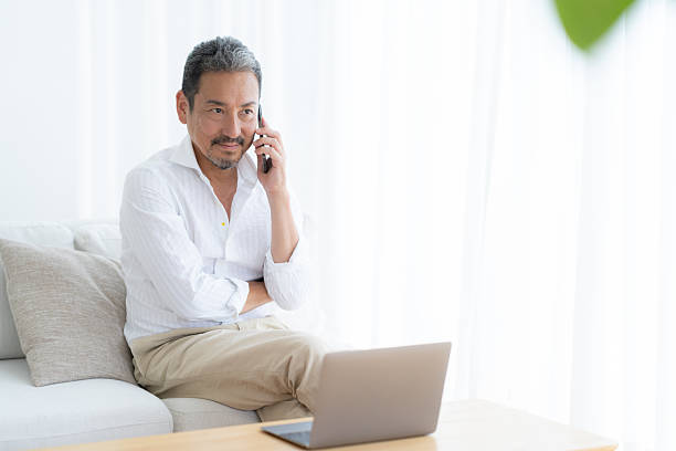 istock middle-age man looking at a computer in the living room 2243527881