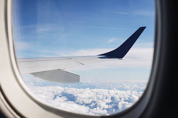 istock Airplane wing view from window above clouds. Blue sky and sunlight creating travel inspiration and freedom feeling. 2243530104