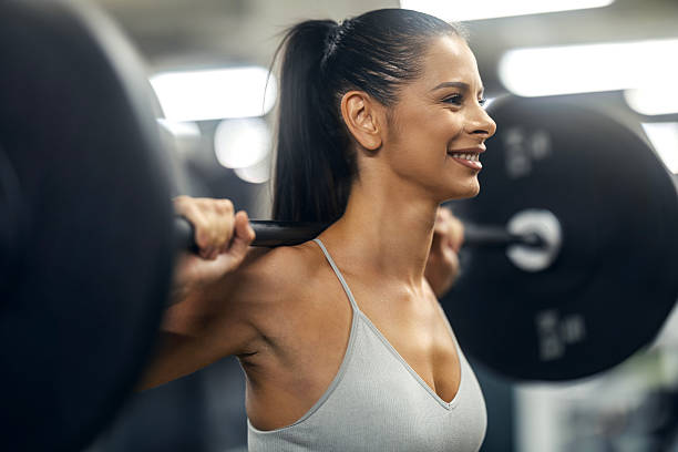 istock Woman weightlifting at the gym, smiling during workout 2243530287