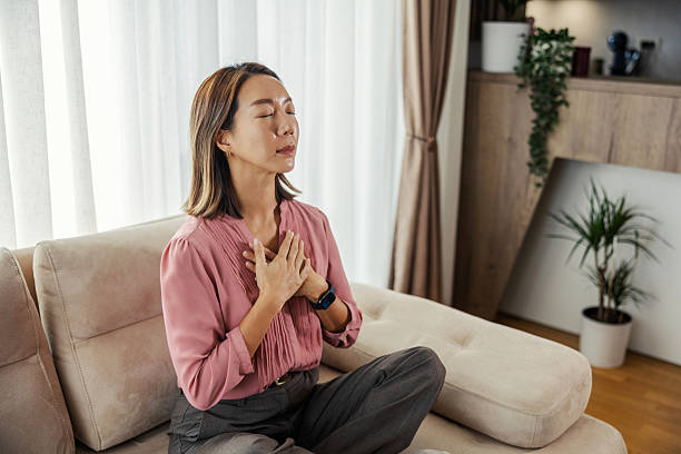 istock Woman meditating on sofa for mindfulness and gratitude 2243532970