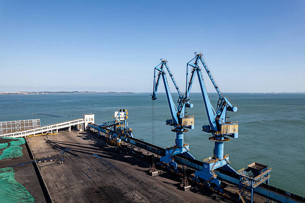 Aerial view of a coal port with a mechanical crane at work