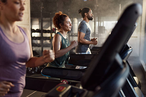 istock Athletic people jogging on treadmills in a gym. 2243538112