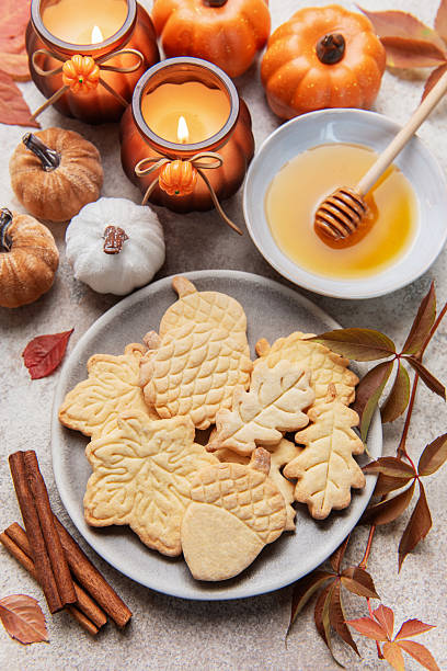 istock Autumn cookies, candles, pumpkins, honey, and cinnamon decorating table 2243538301
