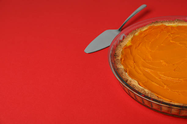 istock Pumpkin pie and cake spatula on red background 2243539714