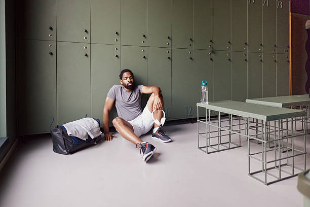 istock Tired black athlete resting on floor in locker room. 2243539847