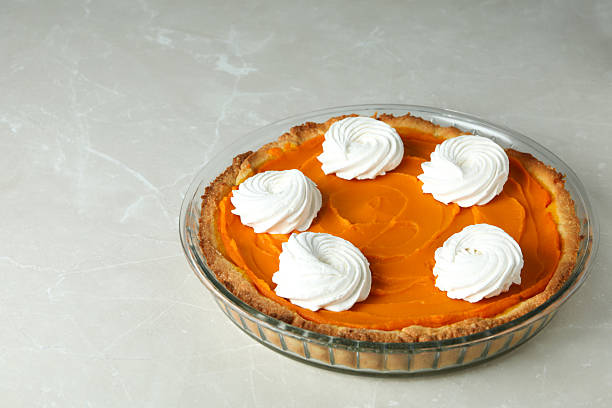 Pumpkin pie in round dish on gray background