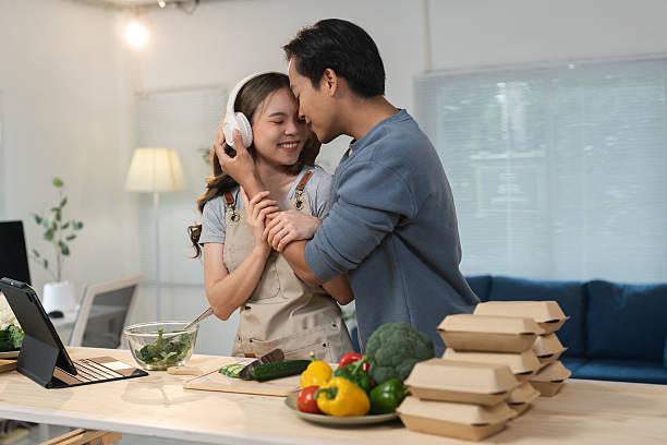 istock Young couple is embracing in their modern kitchen while preparing a healthy meal, showcasing love, togetherness, and a balanced lifestyle 2243541479