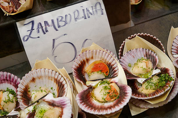 Baked black scallops, locally known as zamburiña at La Boqueria Market. Barcelona. Spain.