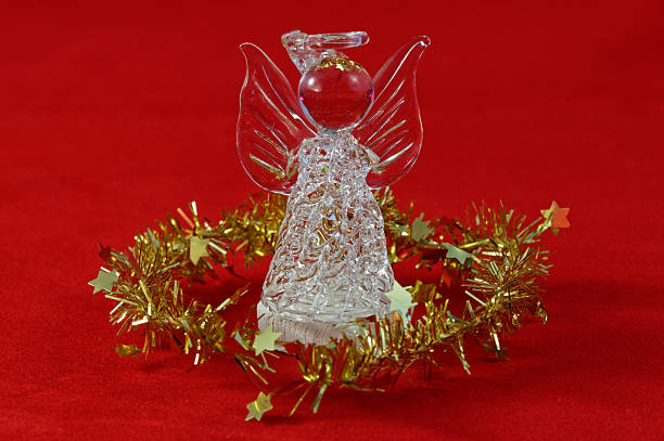 An angel is surrounded by golden tinsel on a red background