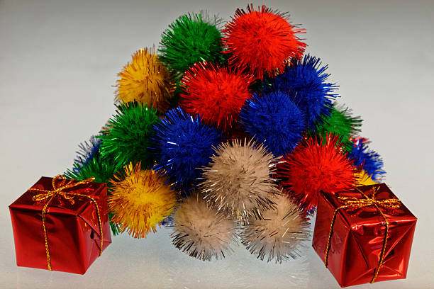 istock A pile of multi coloured pom poms with a wrapped present in the front 2243545286