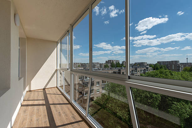 istock Modern Home Enclosed Balcony with Large Windows Overlooking a Lush Green Landscape 2243545950