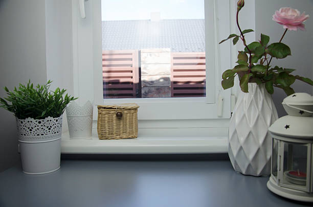 Decorative home interior with plants, wicker box and vase on window sill