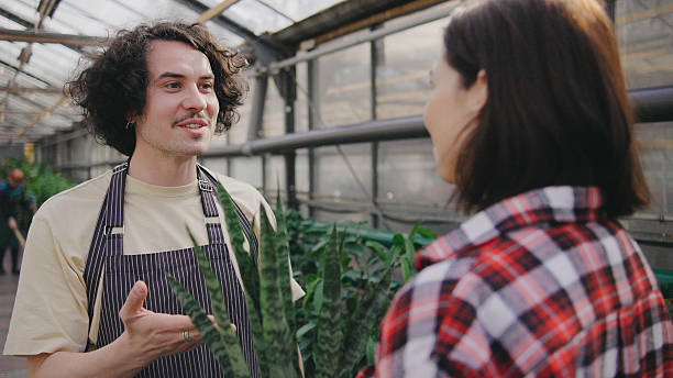 istock Friendly conversation between a plant shop worker and a customer in a greenhouse during the afternoon 2243552983