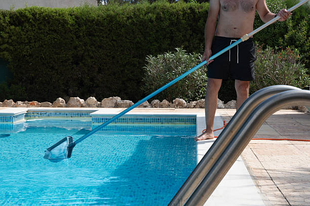 istock A man is thoroughly cleaning his swimming pool using vacuum equipment on a sunny, bright day 2243557694