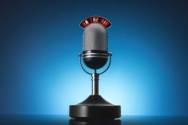 A vintage silver microphone on a stand against a blue studio backdrop. Perfect for radio, podcasting, voiceovers, and broadcasting projects with a professional, retro feel.