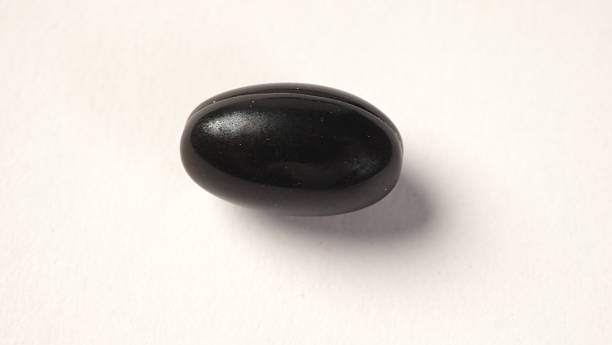 istock A close up of black capsule or vitamin on white background. 2243559353