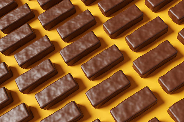 istock An array of mini chocolate bars on a yellow background. Illustration of the concept of confectionary, snack, candies and obesity 2243559548