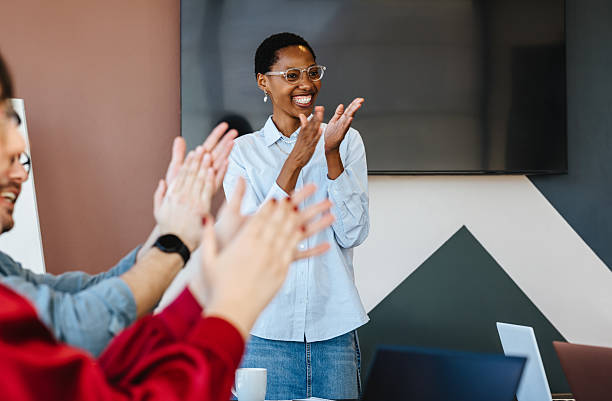 istock Smiling team applauding a speaker during a meeting in a modern office 2243560842