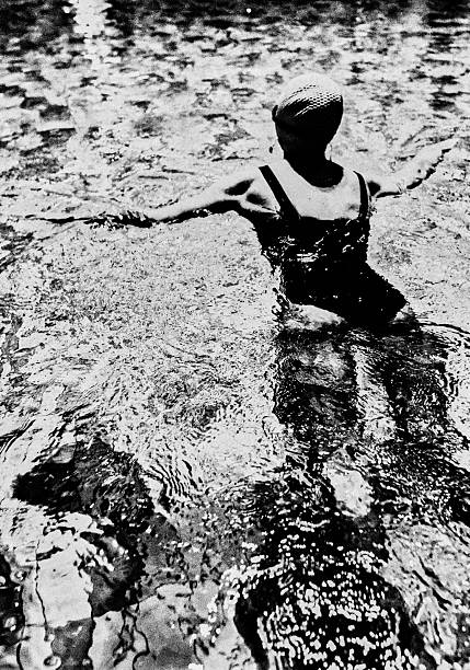 Underwater shooting, young woman closing eyes in white dress.