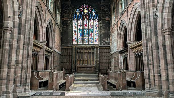 Abandoned church abbey closed down. Derelict religious building arches, sunlight through stained glass windows, gothic stone brick pillars. Eerie chapel architecture, arched columns, choir stalls, nave, chancel, prayer benches, aisle to altar deserted pews. Empty place of worship, sacred sanctuary, declining churchgoers from lost religion in Britain. Secular shift causing spiritual void and faith erosion in England. Symbol of belief decaying, medieval cathedral interior space.