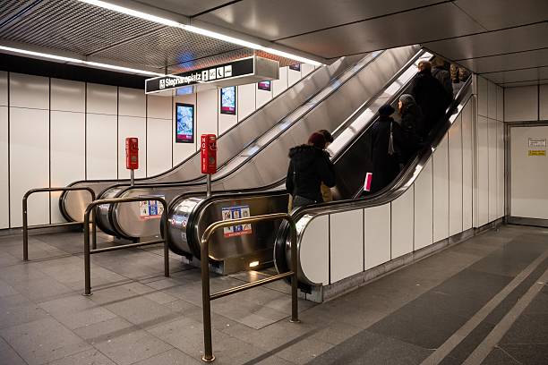 Vienna, Austria - January 06, 2015 - Busy urban subway scene with diverse adults on escalator in modern transit station.