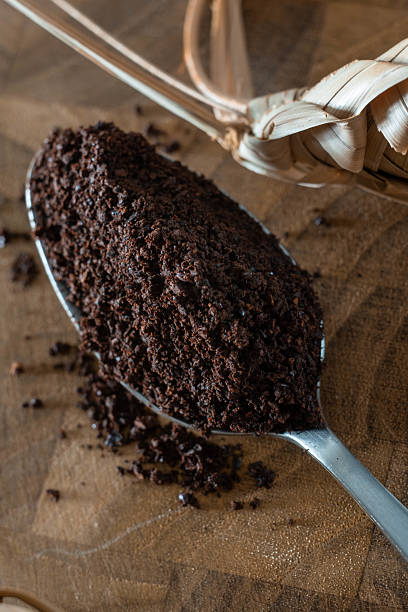 istock A spoon with ground roasted coffee on a wooden board with a braided decoration 2243577344