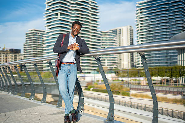istock Black man checking watch on modern city bridge 2243577978